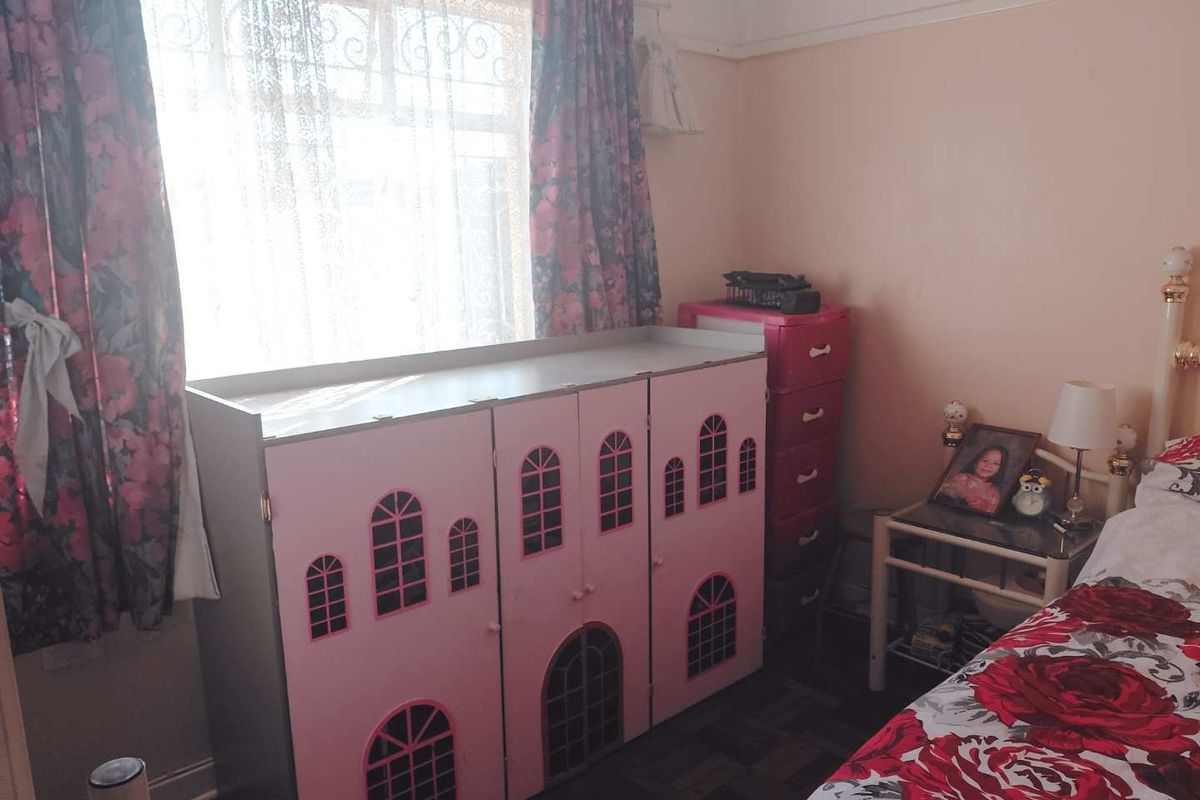 A bedroom featuring classic picture rails and original timber parquet flooring, offering a functional space with traditional architectural details.