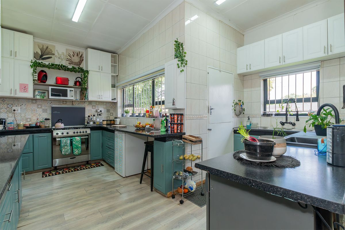 A functional kitchen featuring built-in cabinetry, granite countertops, a gas stove, and tiled backsplash, offering a practical layout with ample storage space.