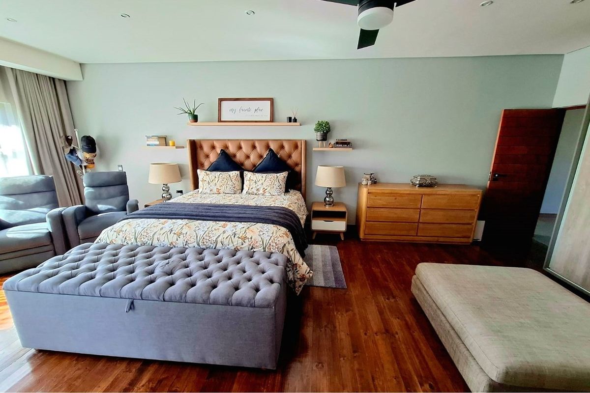 Spacious bedroom featuring warm hardwood flooring, recessed ceiling lighting, and a modern ceiling fan, creating a comfortable and well-maintained living space.