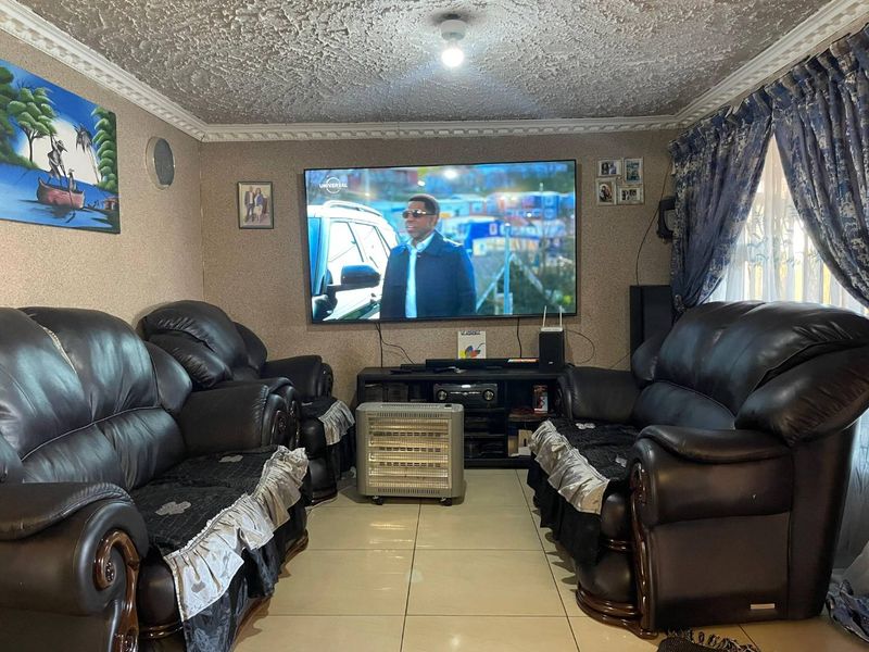 A comfortable living room featuring tiled flooring and a textured ceiling, providing a functional space for relaxation and entertainment.