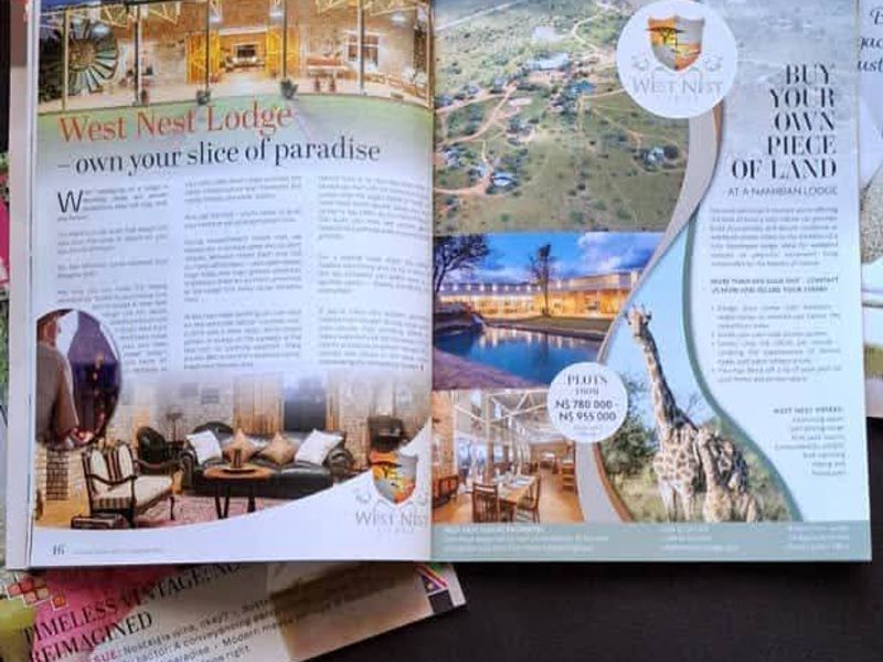 A magazine advertisement featuring promotional photography of West Nest Lodge and available residential land plots.