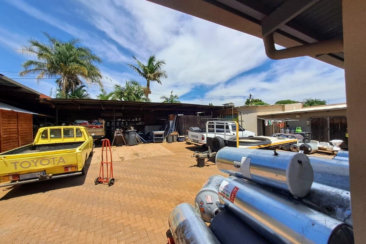An outdoor utility and storage yard featuring paved ground, covered work areas, and open-air storage space suitable for industrial or commercial use.