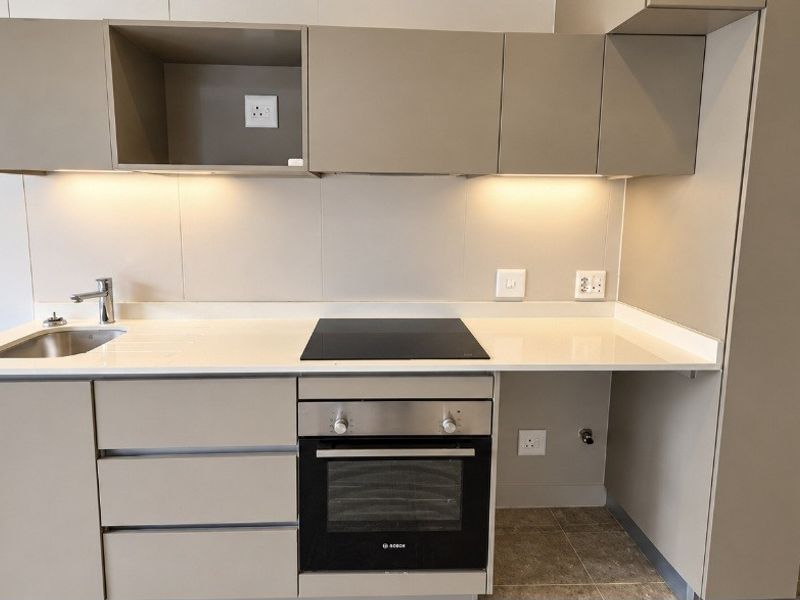 Modern kitchen featuring sleek cabinetry, stone countertops, integrated Bosch oven and hob, and under-cabinet lighting in a clean, contemporary finish.