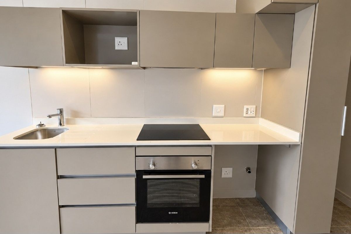 Modern kitchen featuring sleek cabinetry, stone countertops, integrated Bosch oven and hob, and under-cabinet lighting in a clean, contemporary finish.
