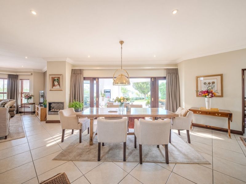 Spacious open-plan living and dining area featuring tiled floors, a built-in fireplace, and large sliding doors providing seamless access to the outdoor patio.