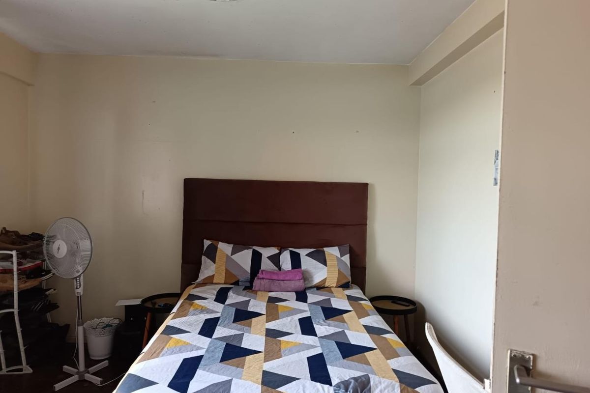 A compact bedroom featuring neutral wall finishes and a standard internal door, requiring minor cosmetic repairs to the ceiling and walls.