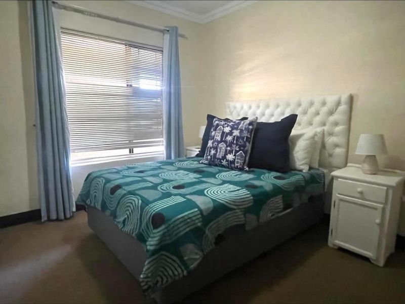 A standard bedroom featuring neutral wall finishes, fitted curtain rails, and venetian blinds, providing a functional and comfortable sleeping space.