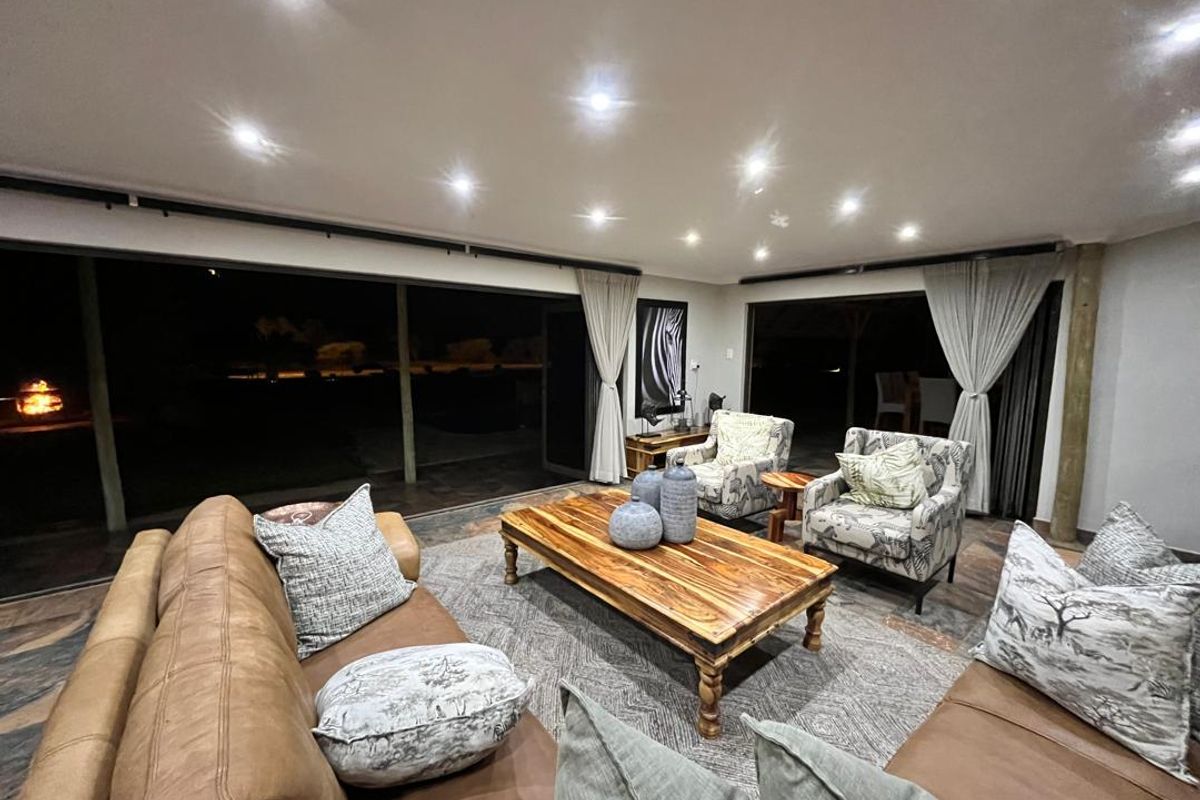 Spacious open-plan living area featuring recessed ceiling lighting and large sliding glass doors that provide seamless access to the outdoor patio.