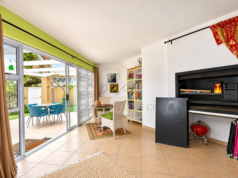 Spacious living area featuring a built-in braai and large sliding glass doors that open onto an outdoor patio space.