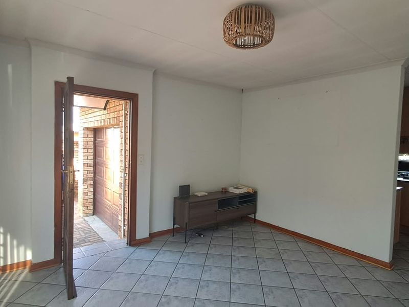 A bright living area featuring tiled flooring and direct access to the exterior garage area.