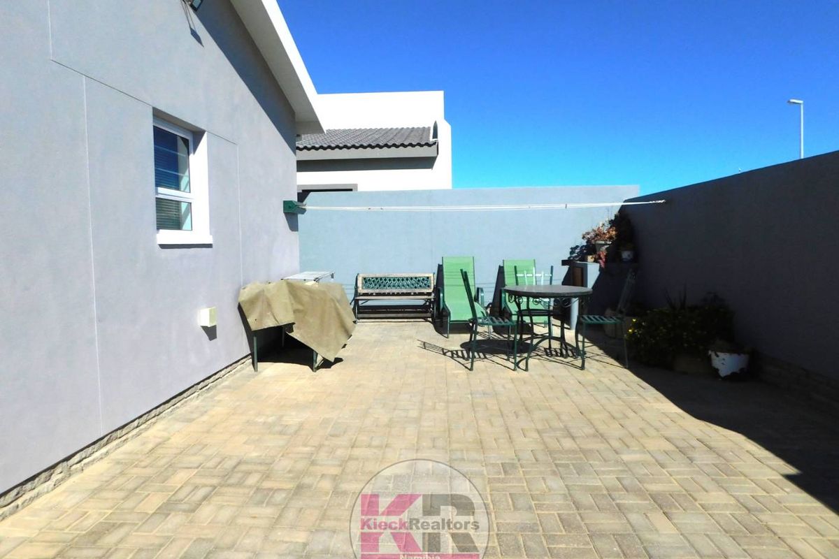 A paved rear courtyard area featuring high boundary walls, providing a private and low-maintenance outdoor space.