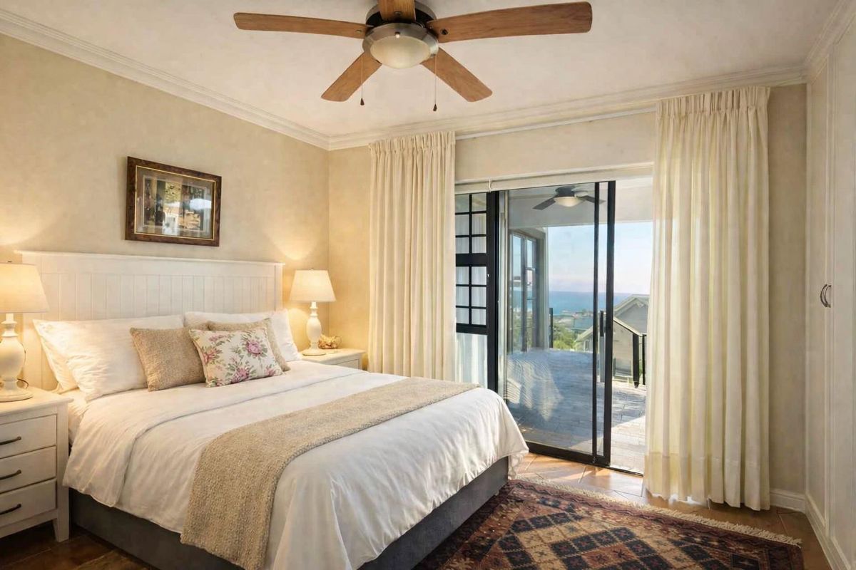 Spacious bedroom featuring a ceiling fan, crown molding, and sliding glass doors that open to a balcony with scenic views.