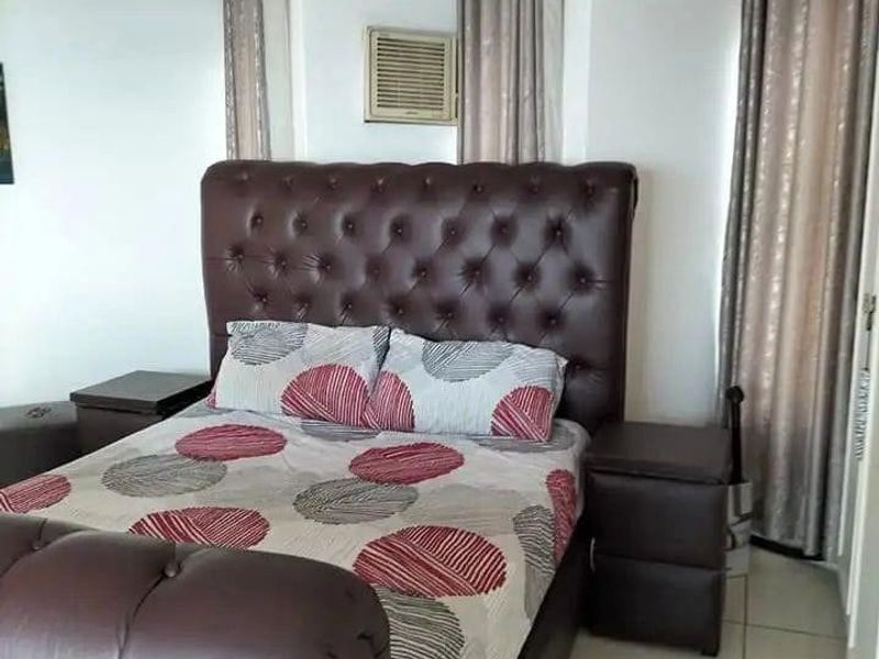 A bedroom featuring tiled flooring and a built-in window-mounted air conditioning unit.