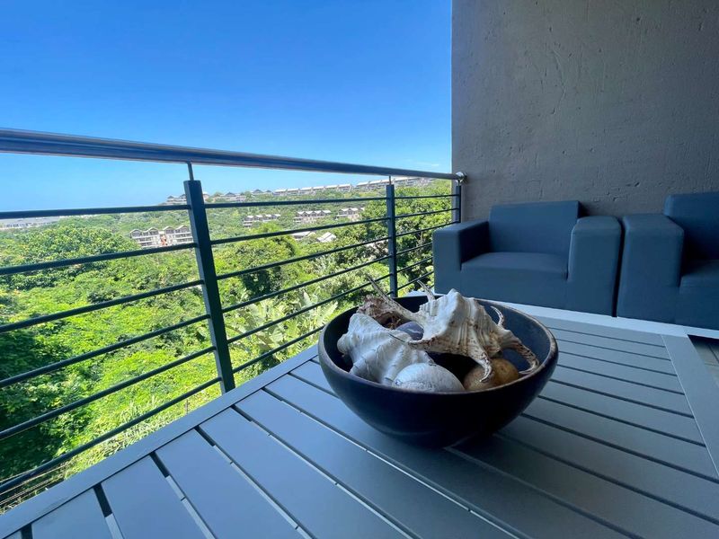 A private balcony featuring a stainless steel balustrade and scenic views of the surrounding landscape.