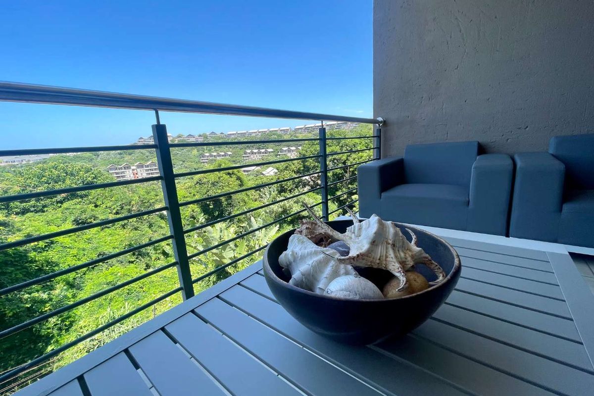A private balcony featuring a stainless steel balustrade and scenic views of the surrounding landscape.
