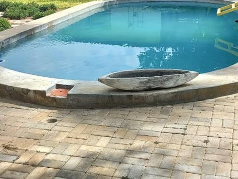 Outdoor pool area featuring a paved patio and a swimming pool with a view of the adjacent outbuilding.