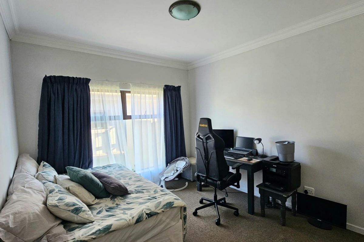 A functional bedroom featuring carpeted flooring, ceiling cornice detailing, and a central flush mount light fixture.