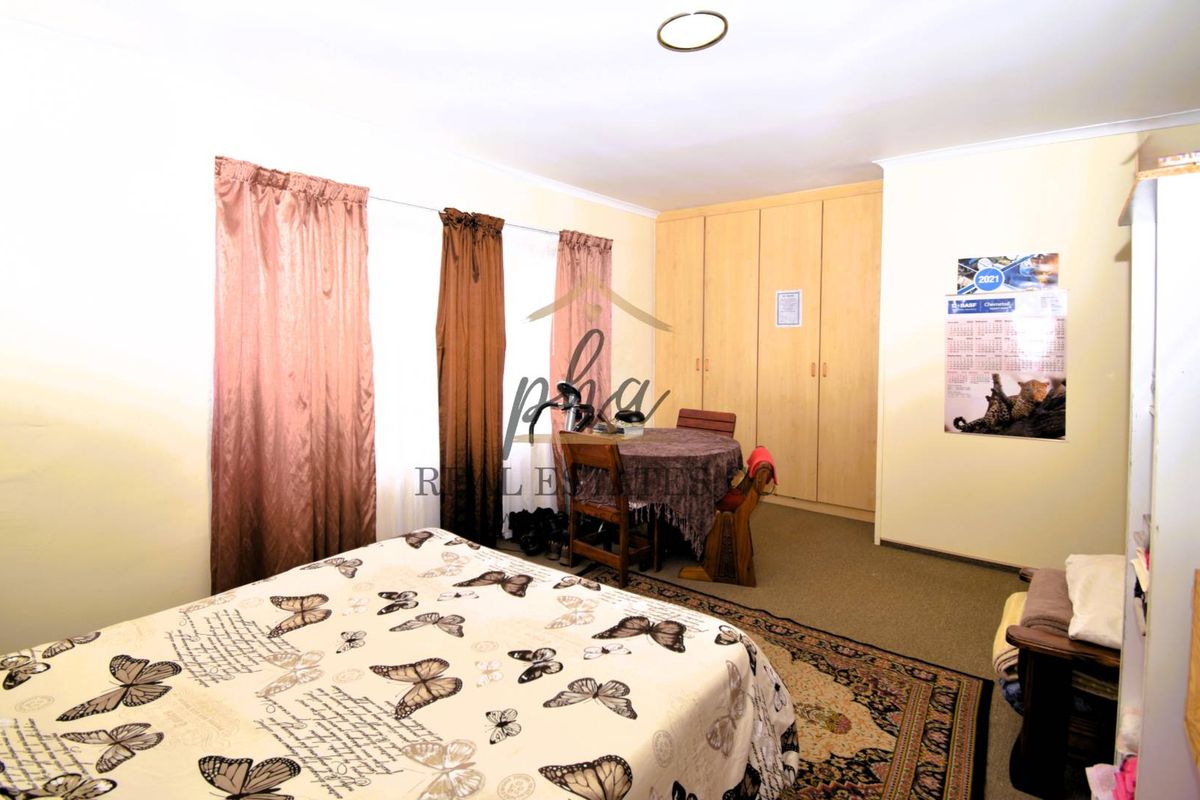 A bedroom featuring built-in wooden cupboards and carpeted flooring, providing ample storage space.