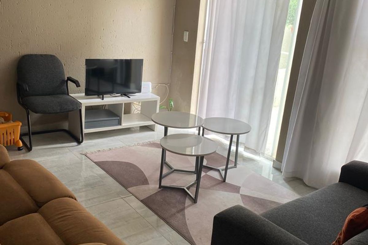 A living room featuring tiled flooring and a sliding glass door providing access to the exterior.