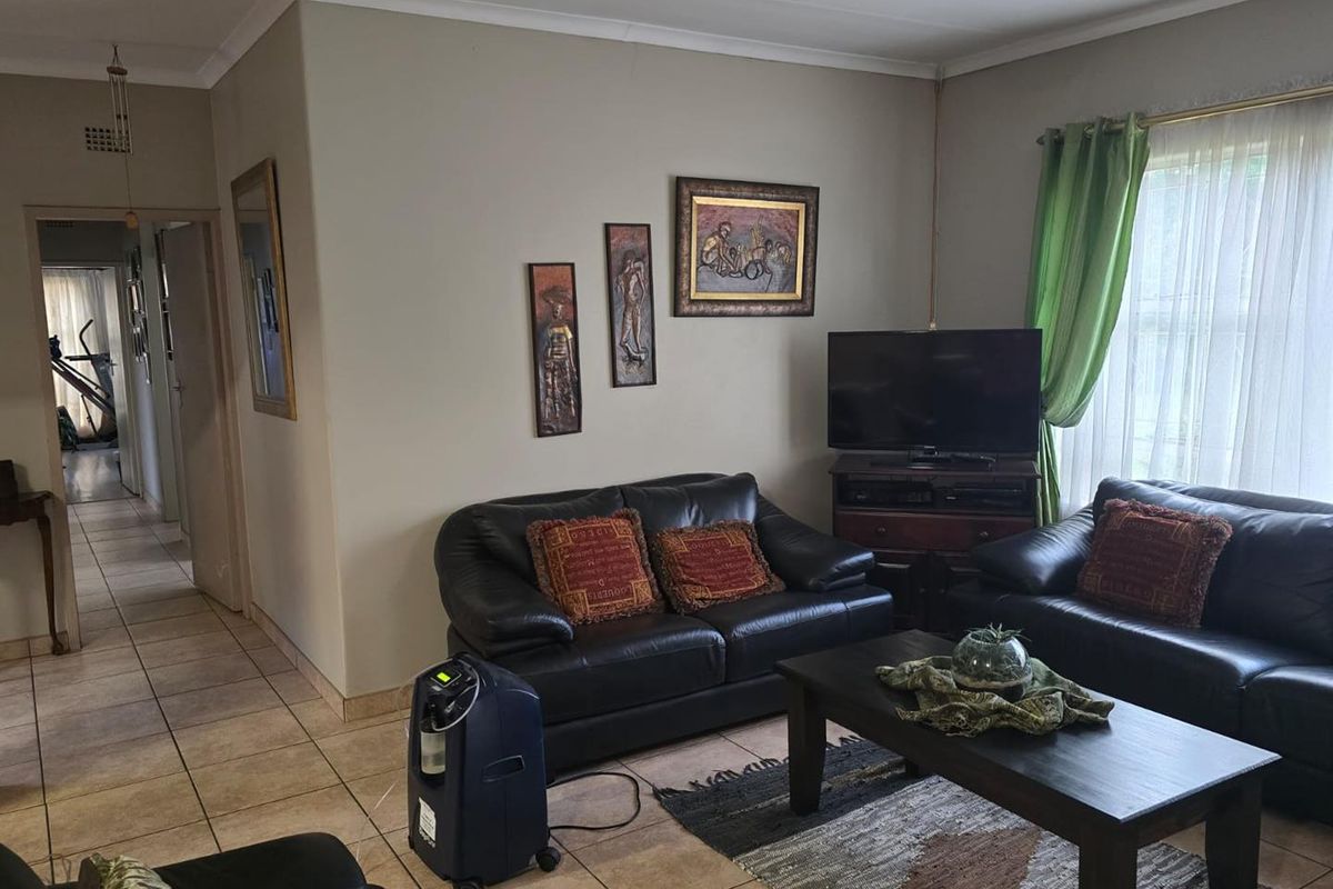 A living room featuring tiled flooring and cove cornicing, providing a functional and neutral space for relaxation.
