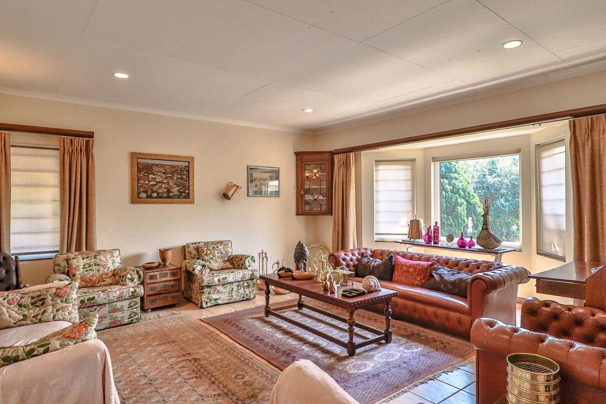 A spacious living room featuring a large bay window, recessed downlighting, and tiled flooring, offering a comfortable and traditional living space.