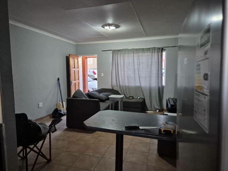 Open plan living area featuring tiled flooring and direct access to the exterior, providing a functional layout for daily living.