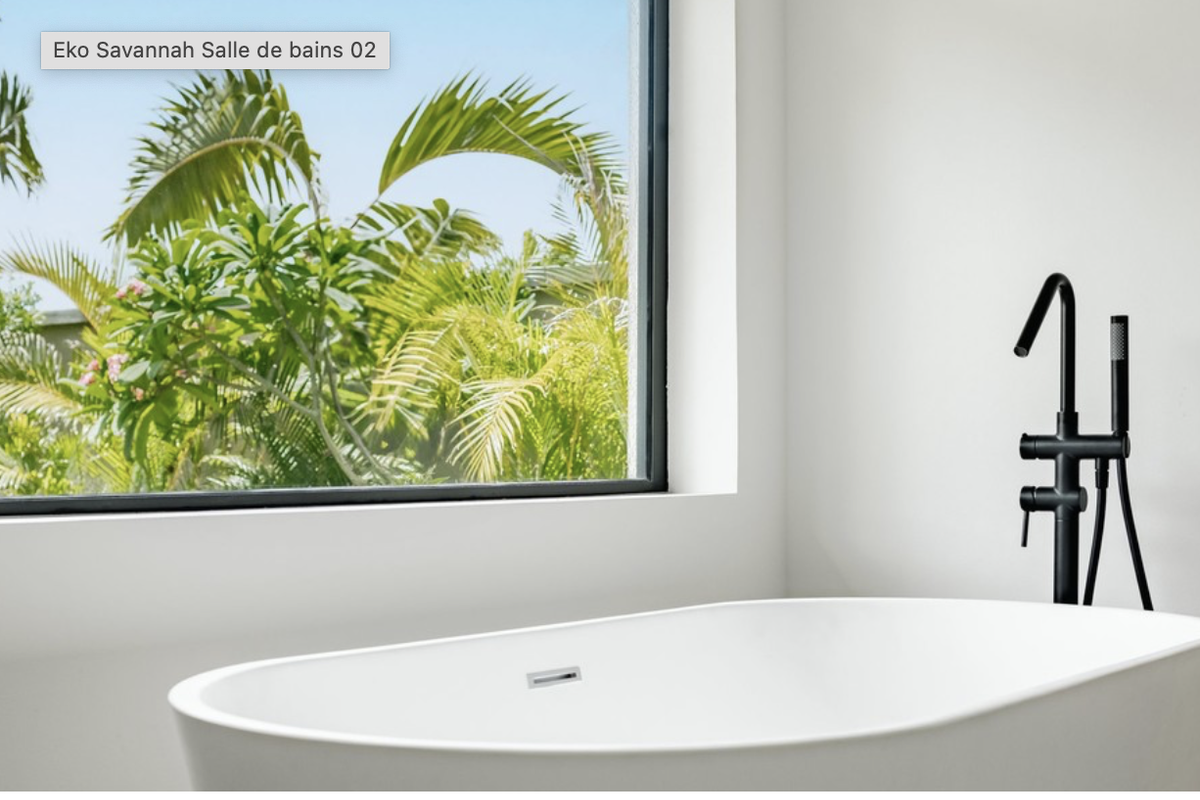 Modern bathroom featuring a sleek freestanding bathtub with matte black fixtures and a large window overlooking lush tropical greenery.