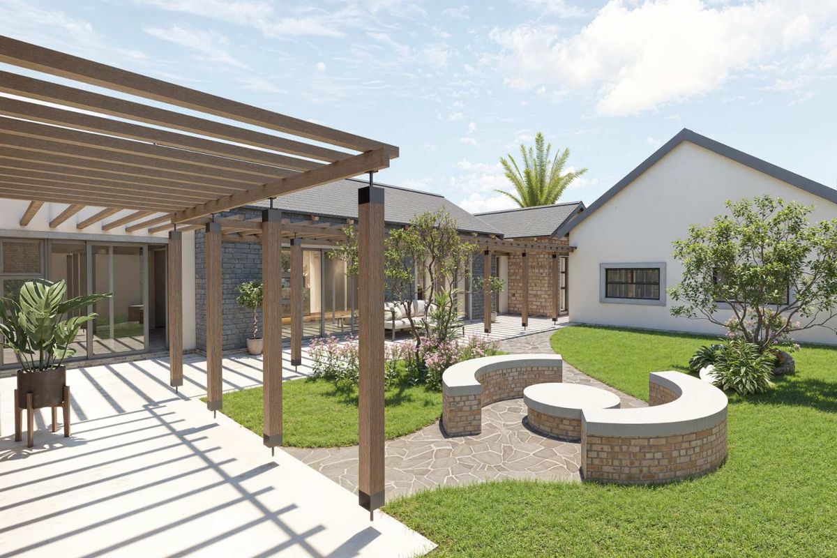 A beautifully landscaped rear garden featuring a wooden pergola, paved pathways, and a built-in circular brick seating area.