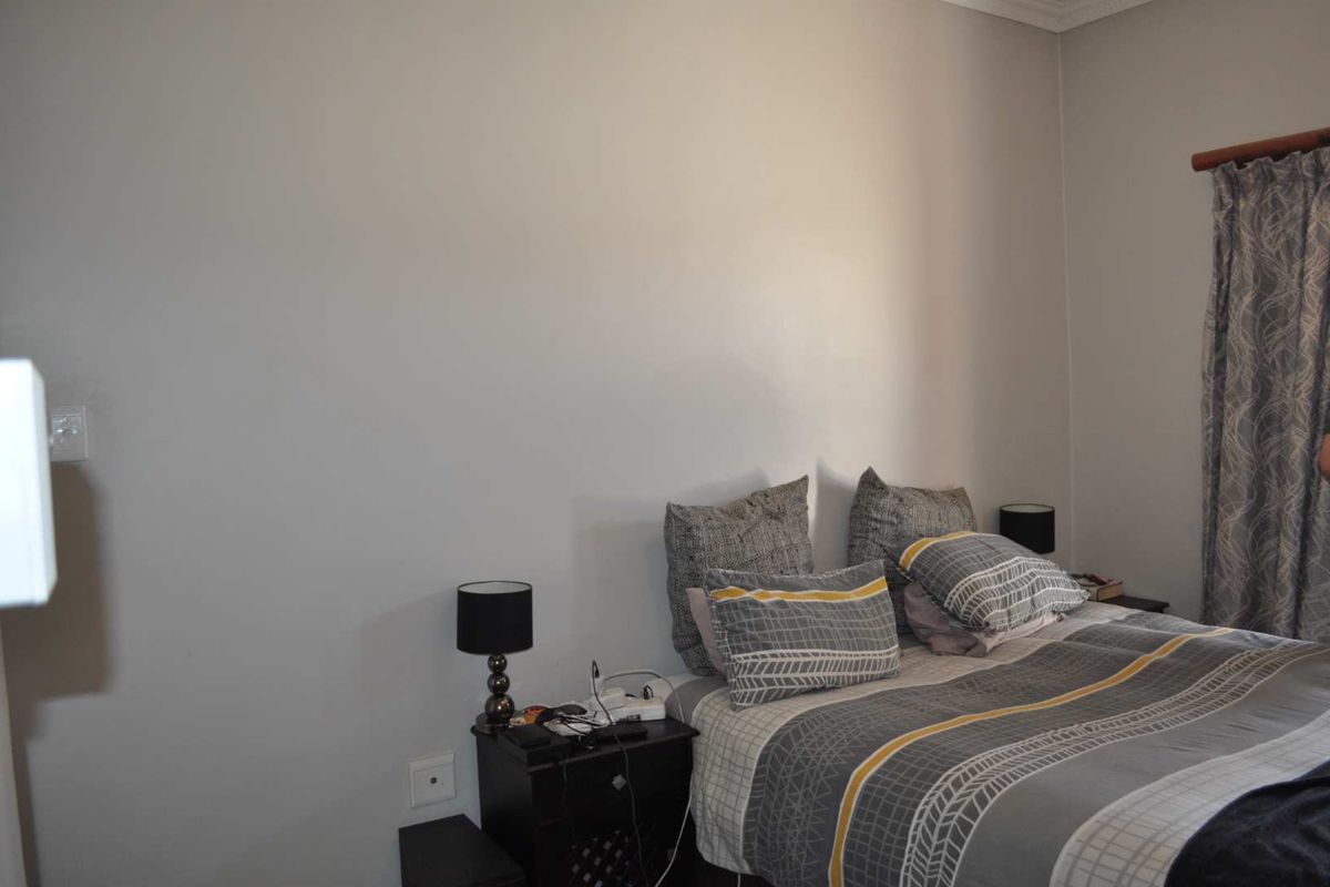 A standard bedroom featuring neutral wall finishes, curtain rod, and functional electrical outlets.