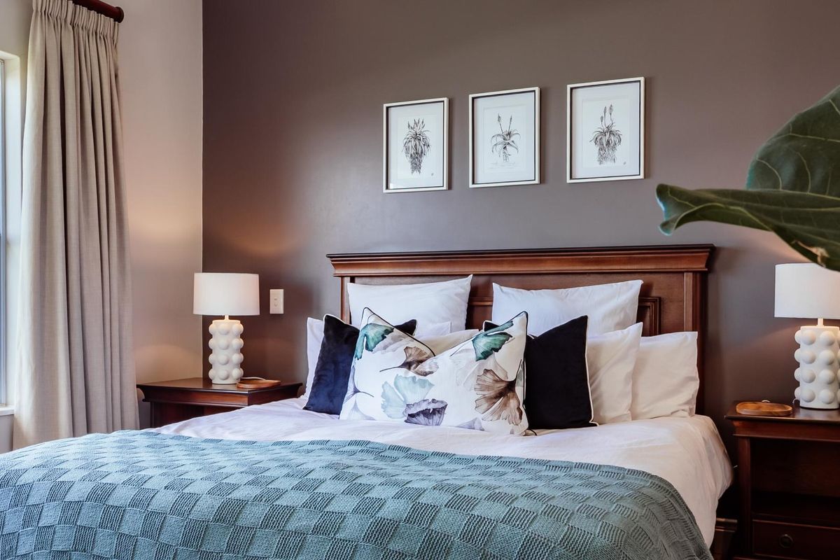 A well-maintained bedroom featuring a dark accent wall, large window with ocean views, and neutral carpeting.