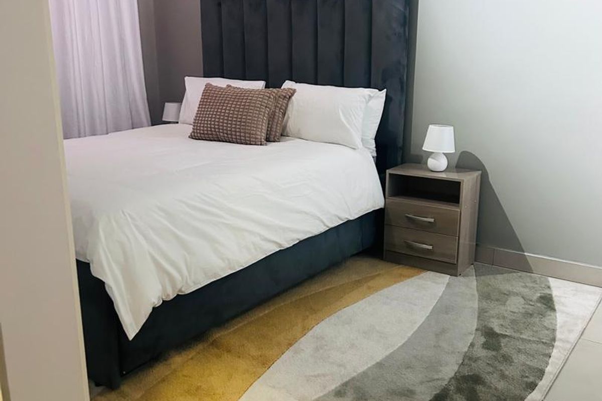 A well-maintained bedroom featuring neutral wall tones, tiled flooring, and a modern curtain installation.