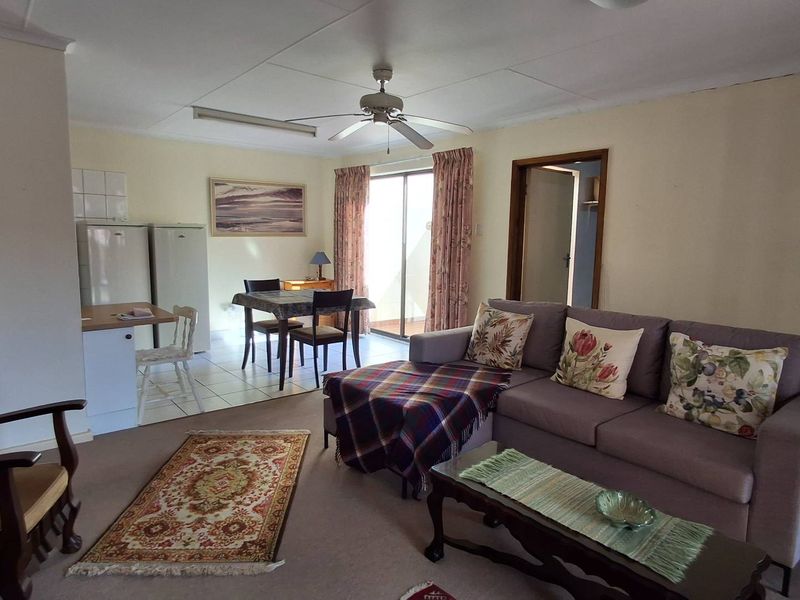 Open-plan living and dining area featuring a ceiling fan, tiled kitchen flooring, and sliding glass door access to the patio.