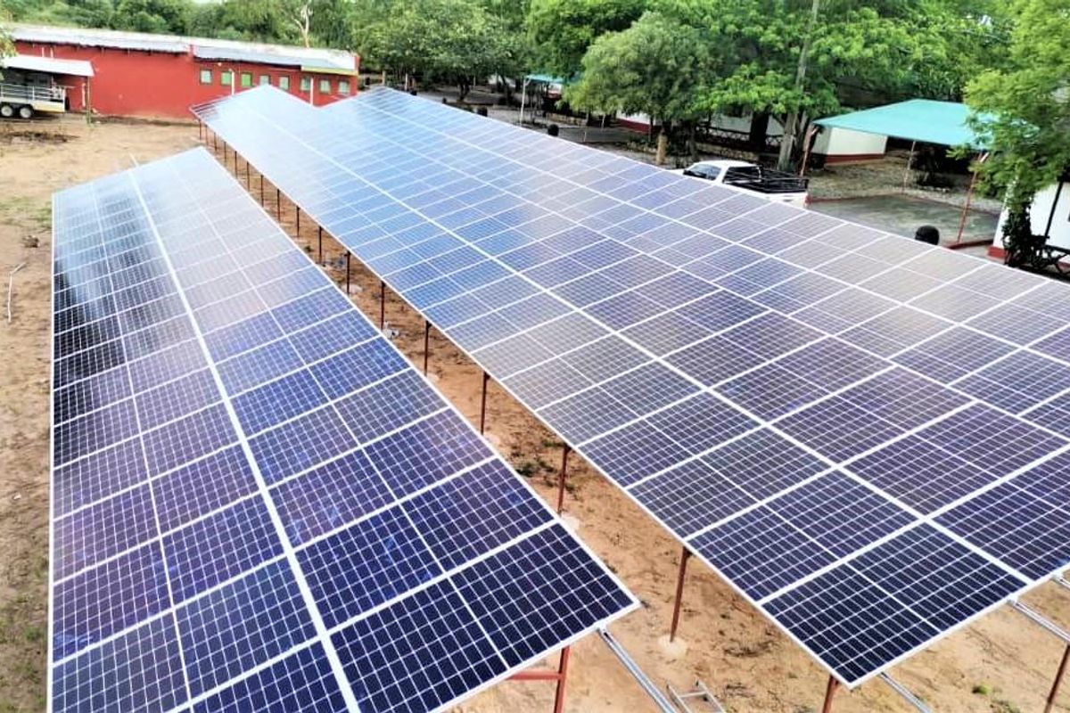 An elevated view of a large-scale ground-mounted solar panel array installation, providing sustainable energy infrastructure for the property.