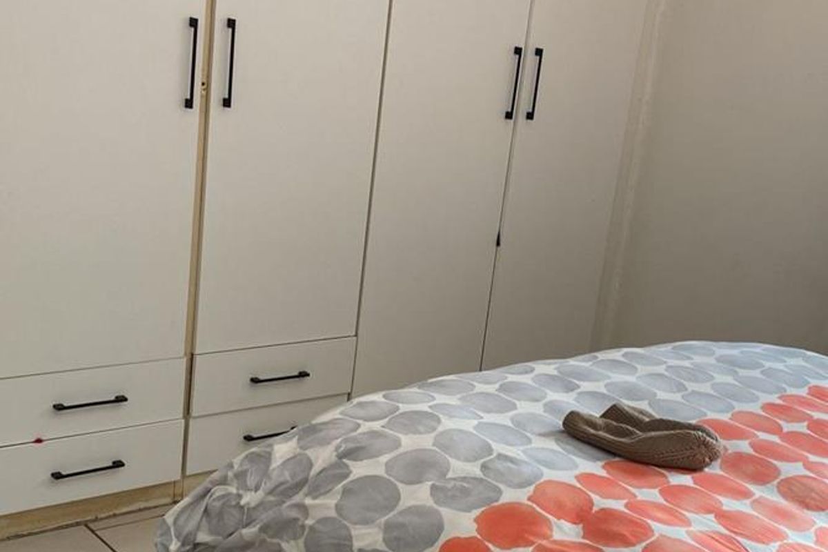 Bedroom featuring built-in white cabinetry with integrated drawers and tiled flooring.