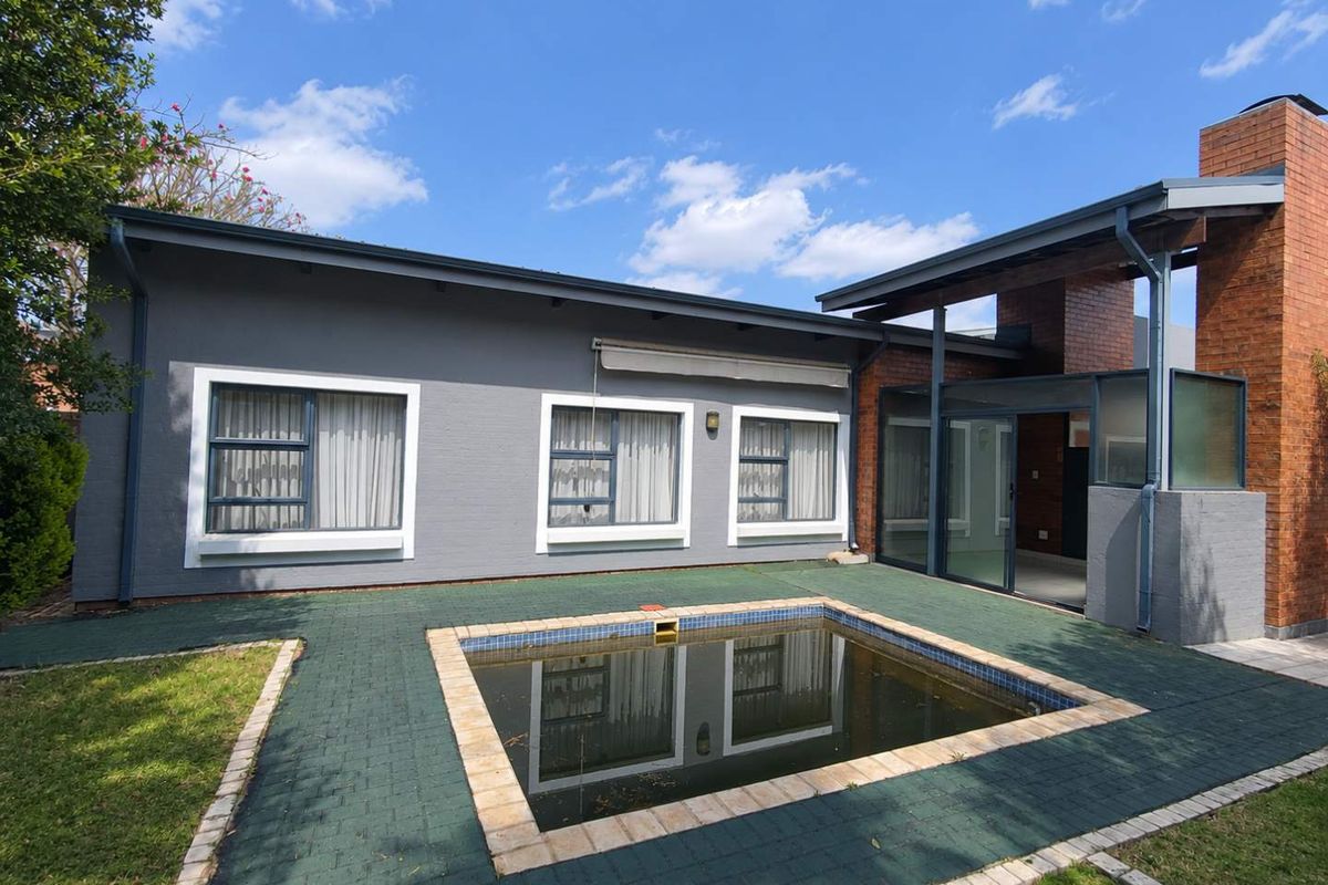 Rear exterior view of the townhouse featuring a paved patio area, a swimming pool, and a brick chimney structure.