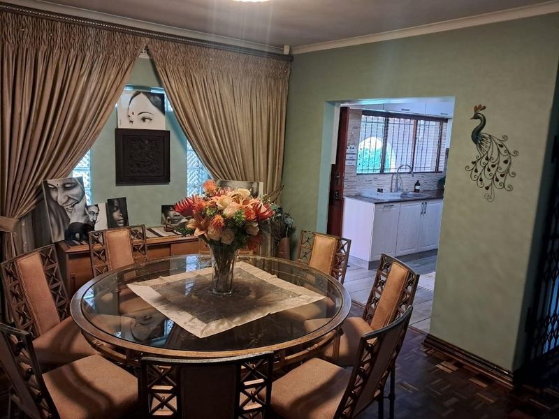 Dining room featuring parquet flooring and coved ceilings, with an open transition into a functional kitchen area.