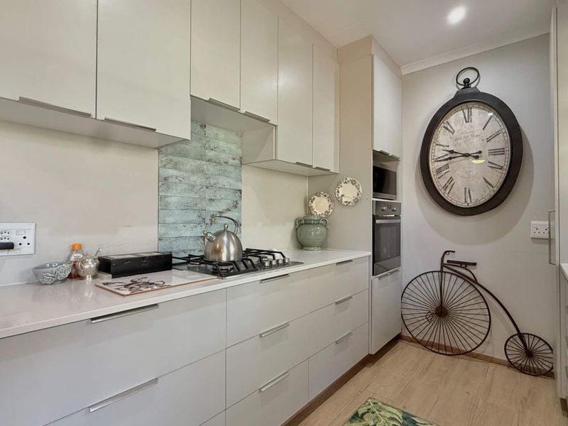 Modern kitchen featuring sleek built-in cabinetry, stone countertops, a gas hob, and integrated appliances, offering a clean and functional workspace.