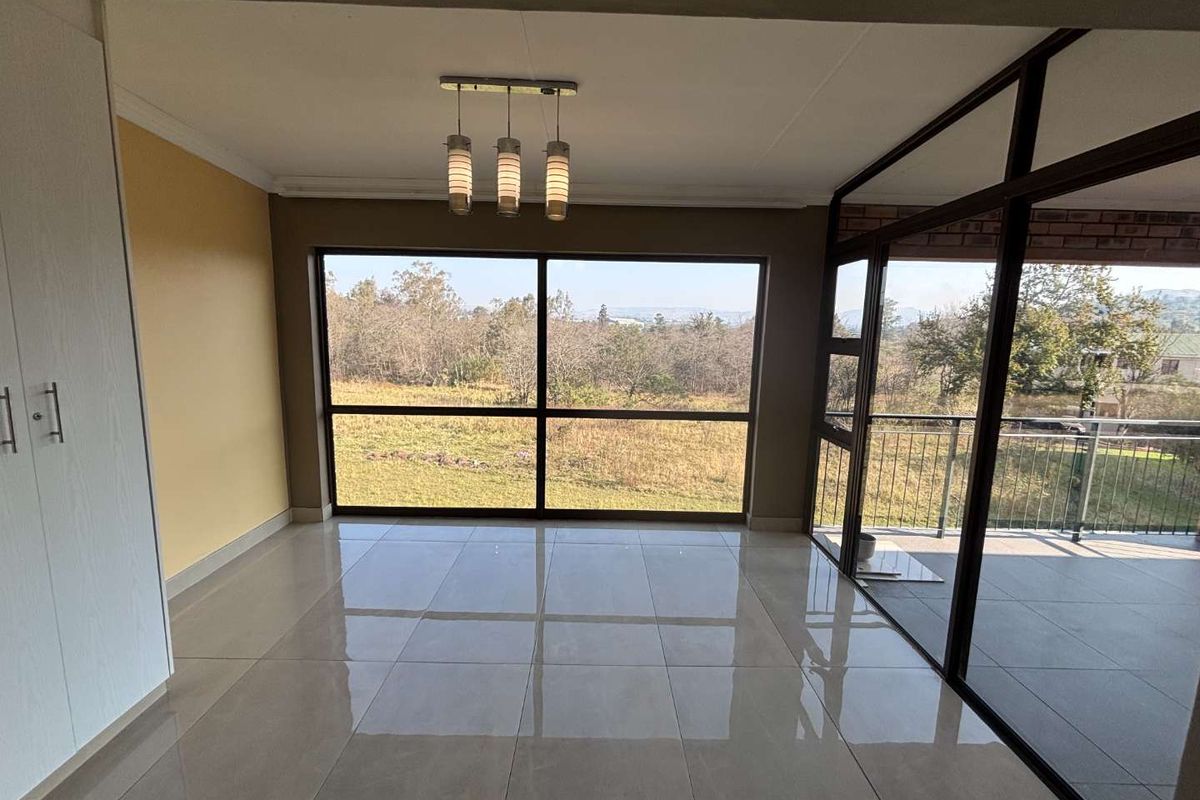 Bright living area featuring large floor-to-ceiling windows, polished tile flooring, and direct access to an adjoining balcony with scenic views.
