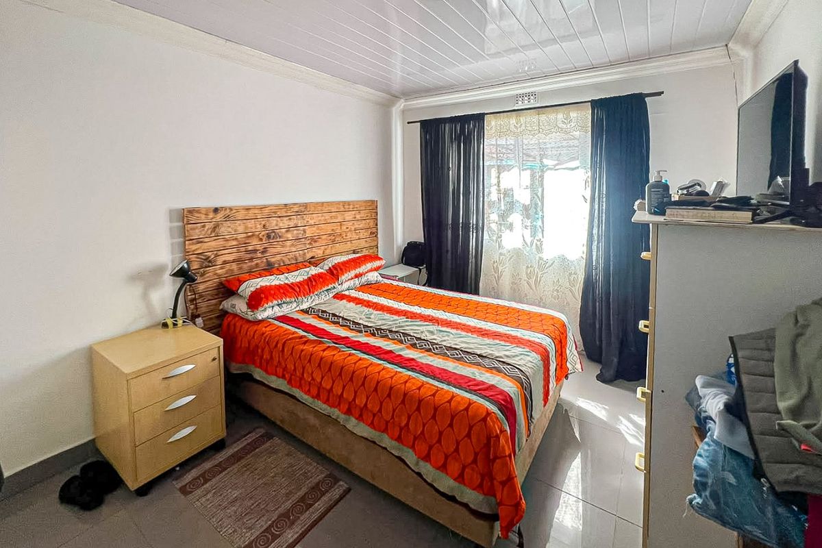 A functional bedroom featuring tiled flooring and a PVC ceiling finish, offering a neutral base for personalization.