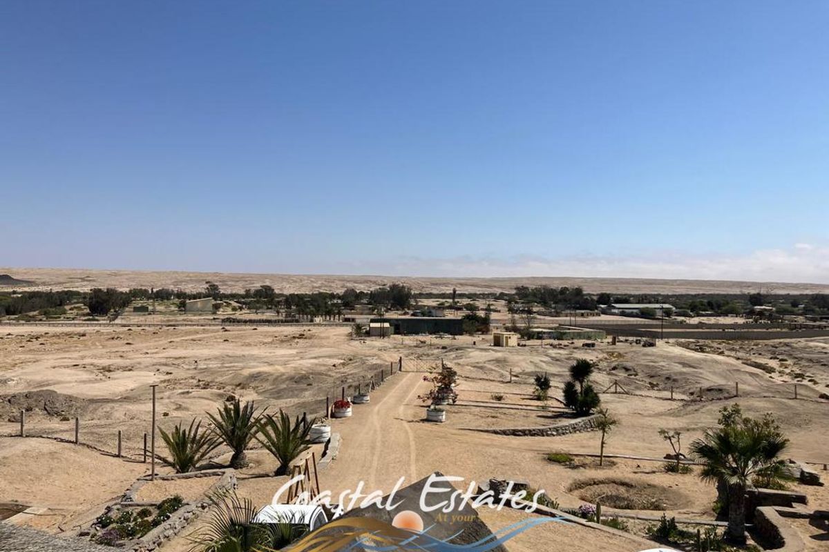 Elevated aerial view of the expansive small holding property, showcasing the surrounding arid landscape and access driveway.