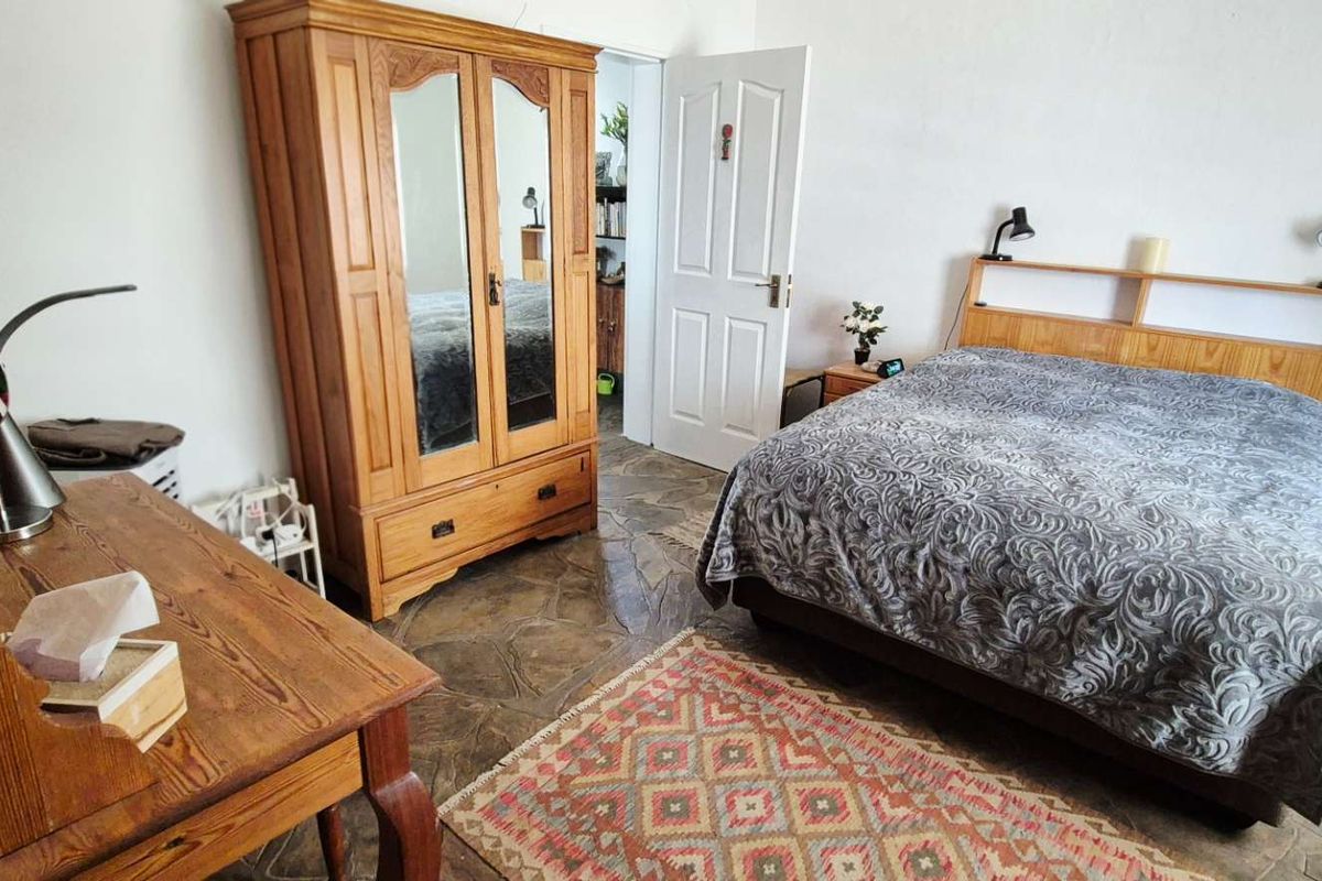 A bedroom featuring natural stone flooring and a standard door, providing a rustic aesthetic.