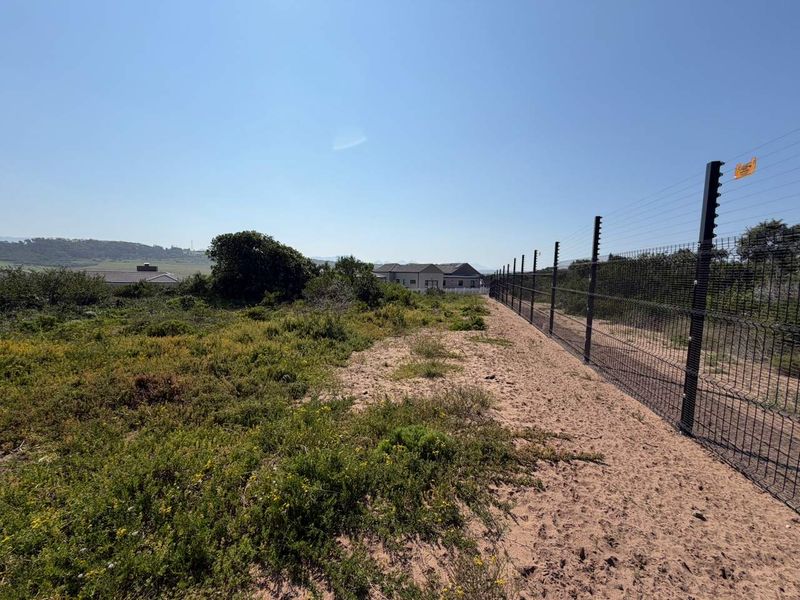 A view of the vacant residential land featuring established perimeter mesh fencing with integrated electric security wires.