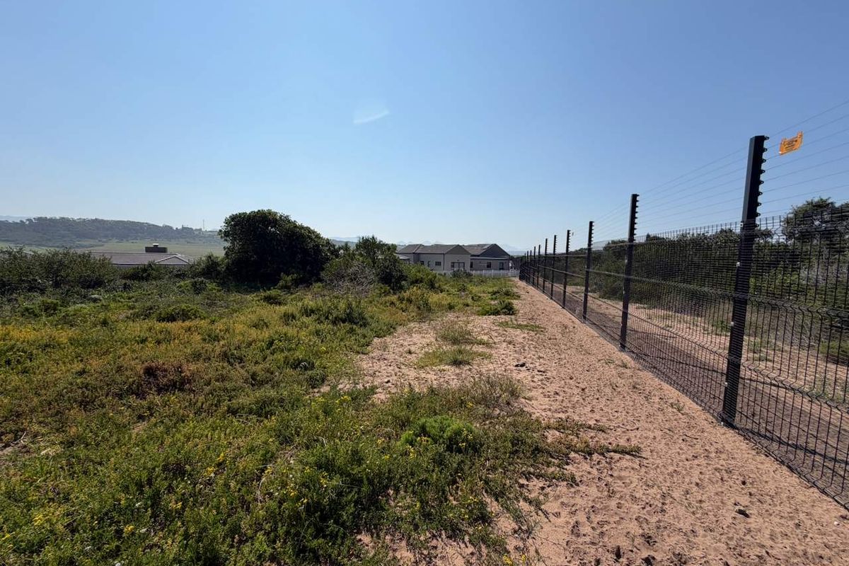 A view of the vacant residential land featuring established perimeter mesh fencing with integrated electric security wires.