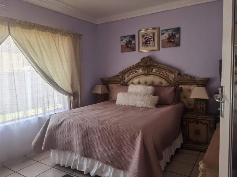 A bedroom featuring tiled flooring and decorative cove cornicing, providing a functional space with neutral wall finishes.