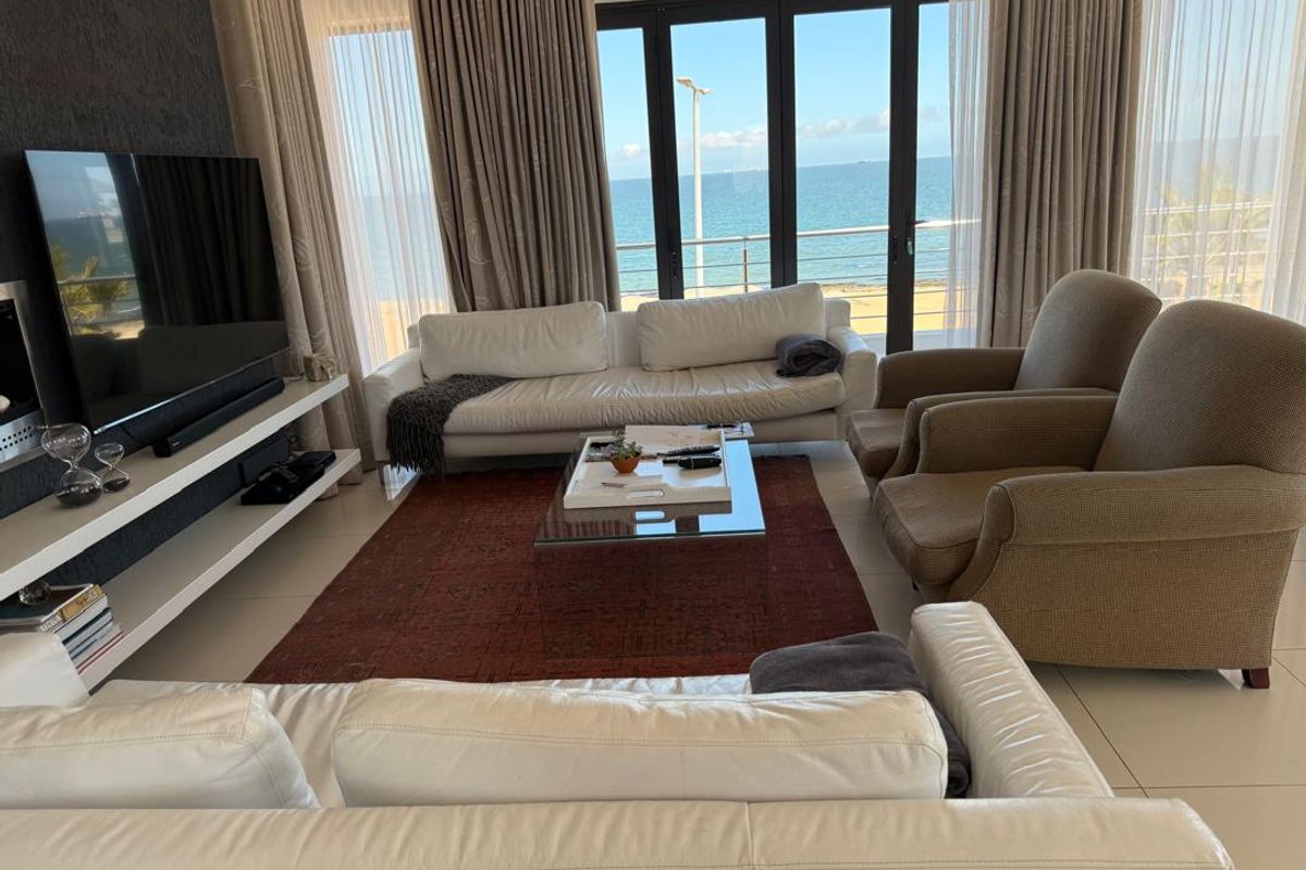 Spacious living room featuring large glass sliding doors that offer expansive ocean views and provide abundant natural light.