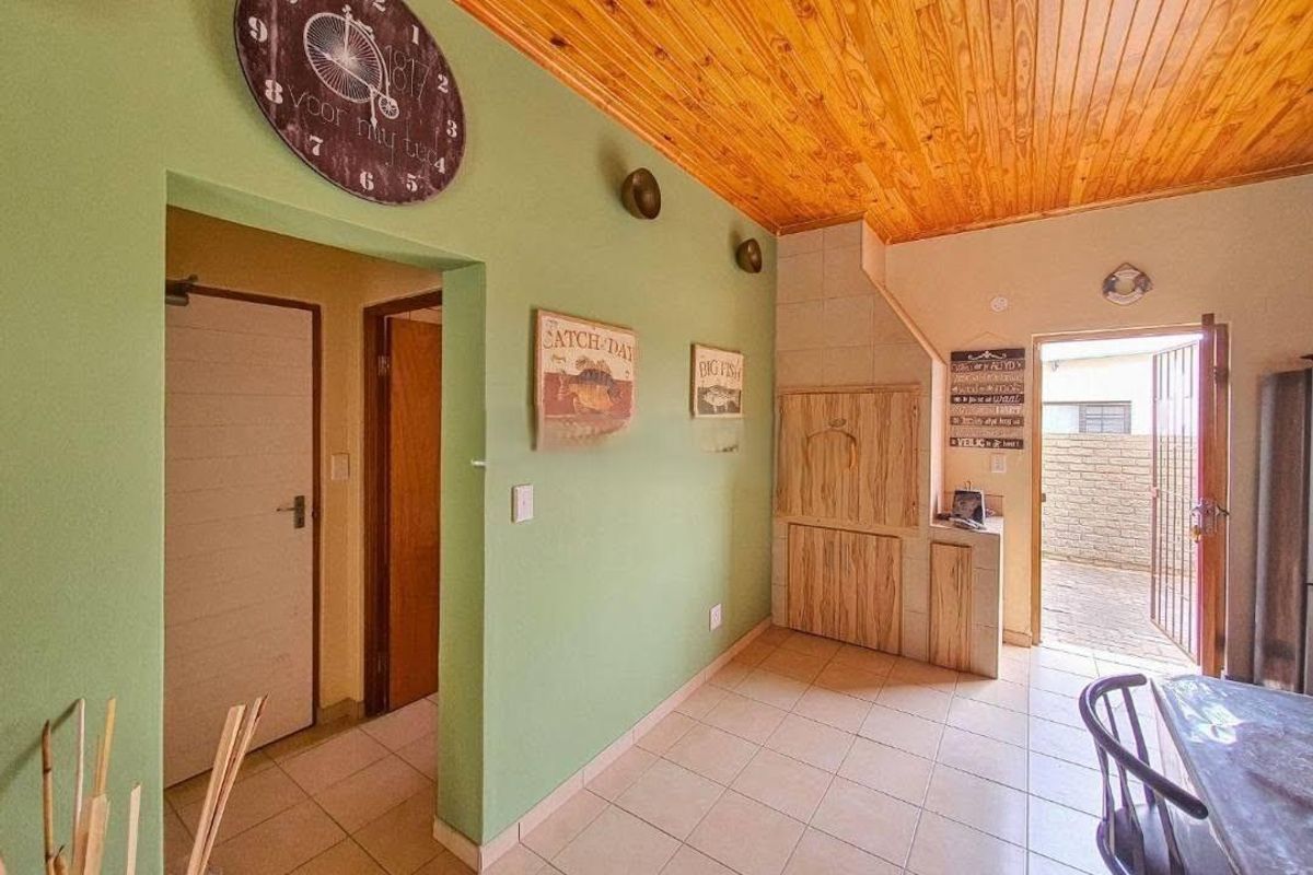 Living area featuring a timber ceiling, tiled flooring, and built-in cabinetry, with direct access to an outdoor patio area.