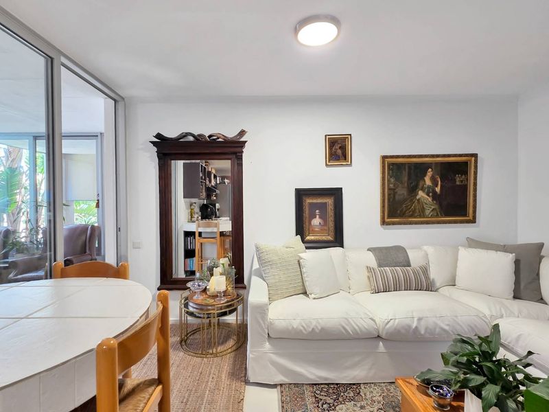 Bright open-plan living and dining area featuring tiled flooring and large sliding glass doors providing seamless access to the outdoor patio space.