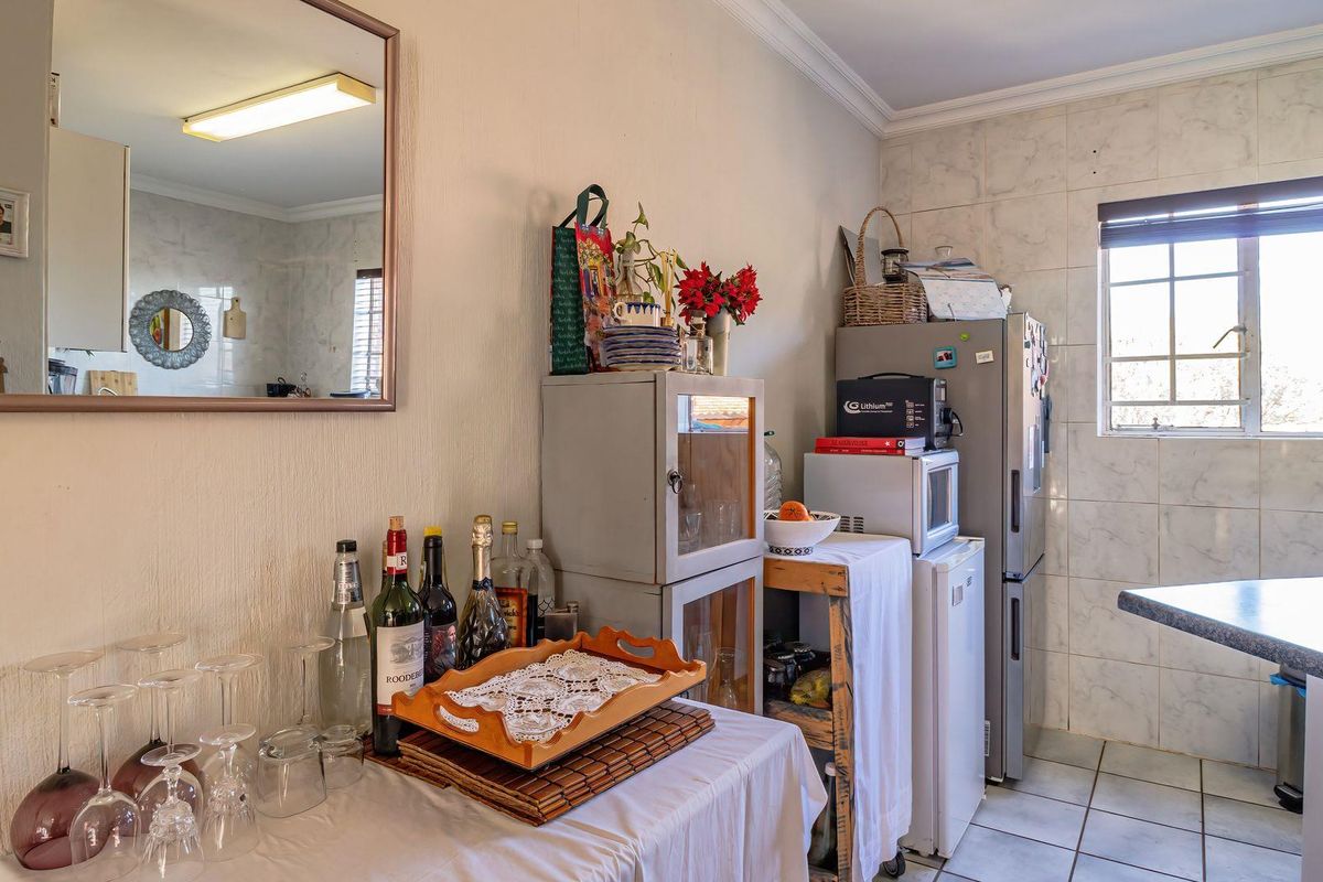 A functional kitchen area featuring tiled flooring, wall tiling, and a window, offering a practical layout for daily use.