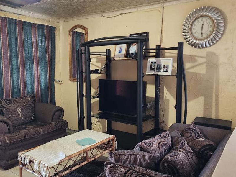 Living room featuring tiled flooring and a textured ceiling. The space requires maintenance and cosmetic updates to improve its overall condition.