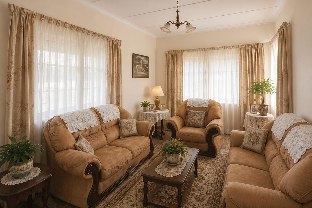 A traditional living room featuring neutral walls, coved cornicing, and large windows that provide ample natural light.
